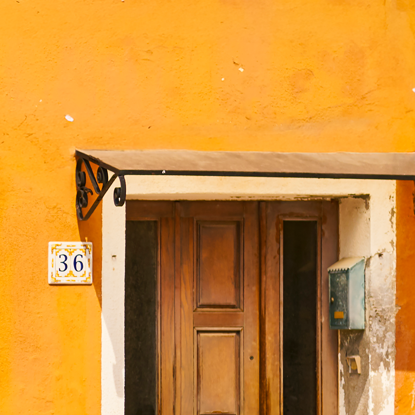 Wooden door with number 36 on a yellow wall