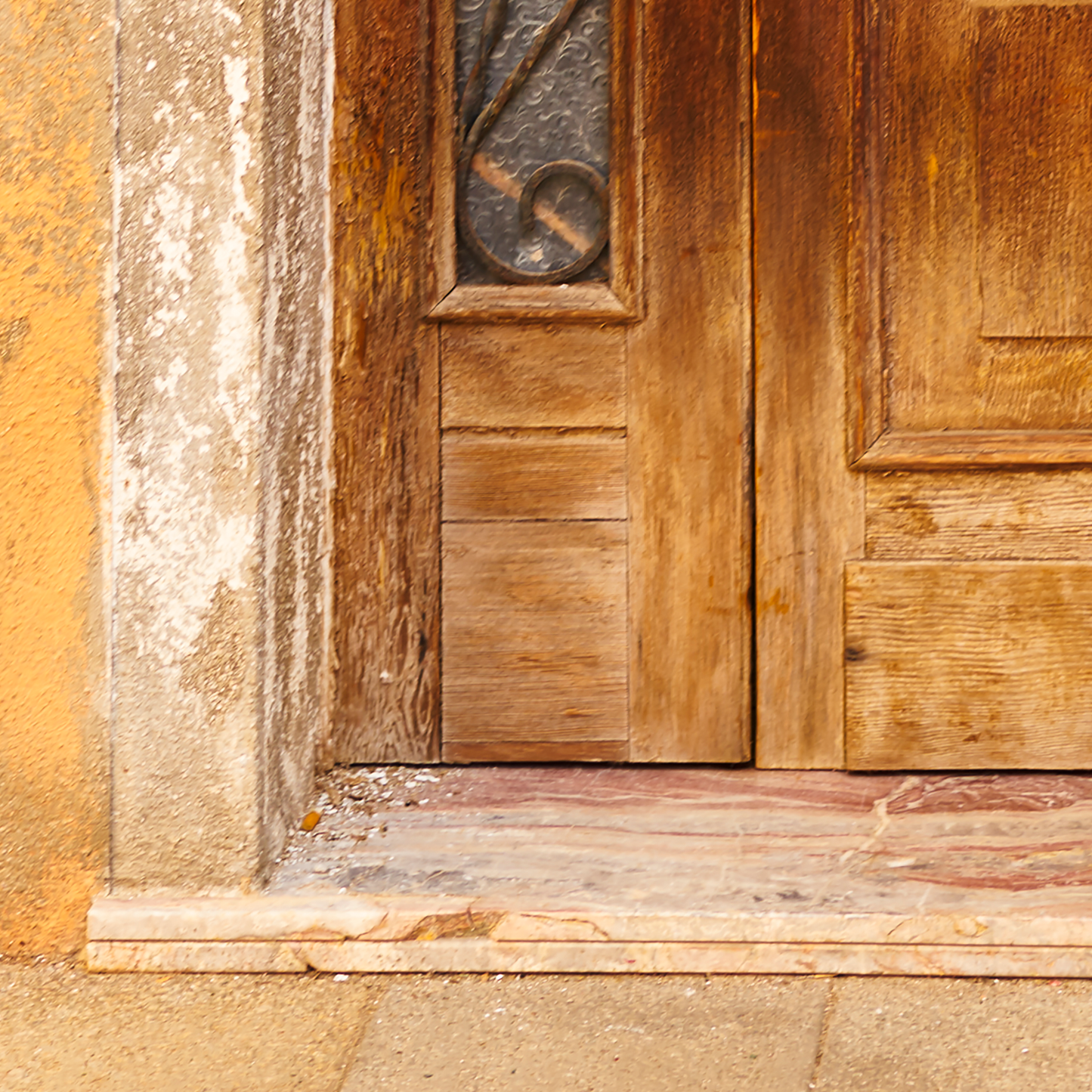 Close-up of a wooden door with stone base and wall.