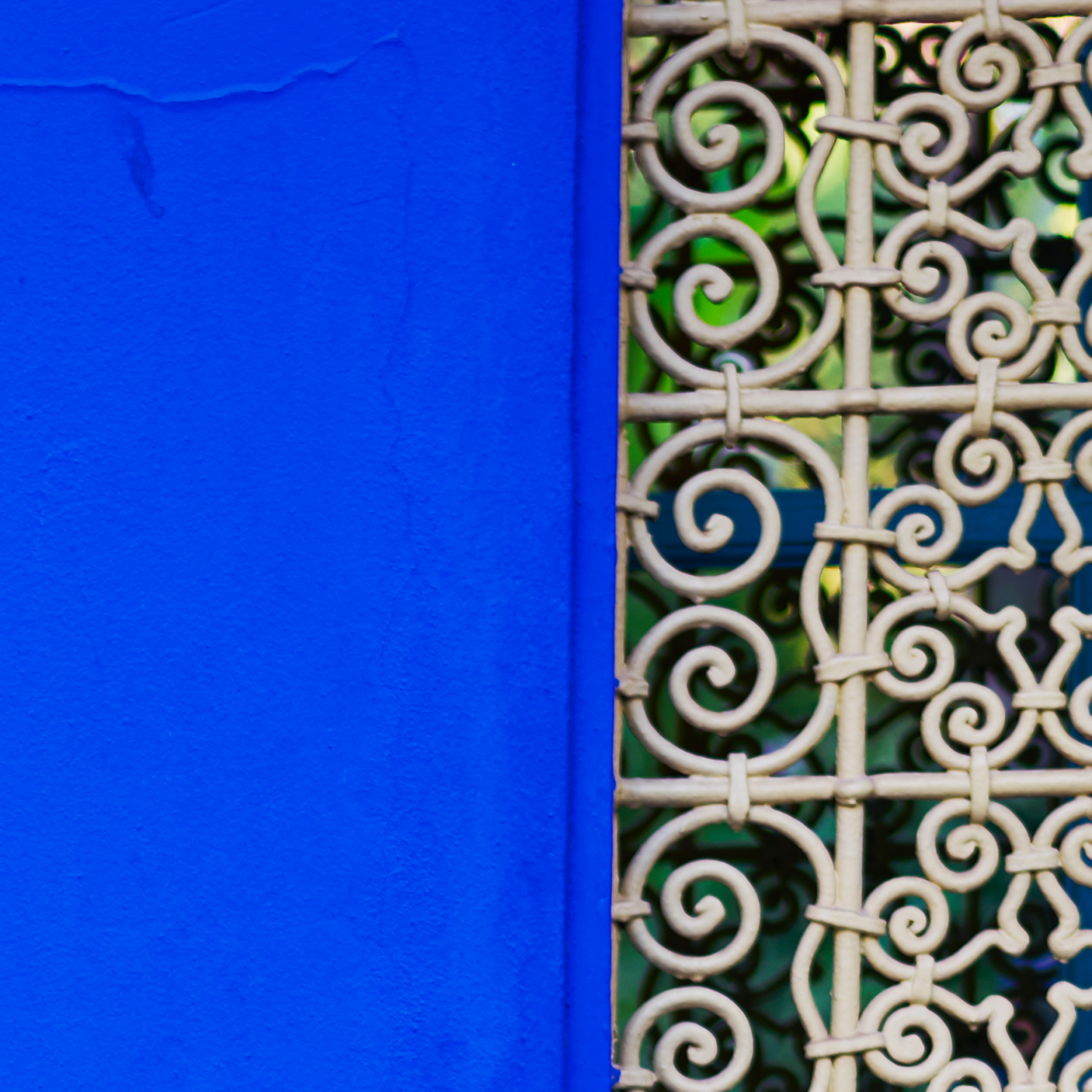 Decorative white metal grille on a blue wall