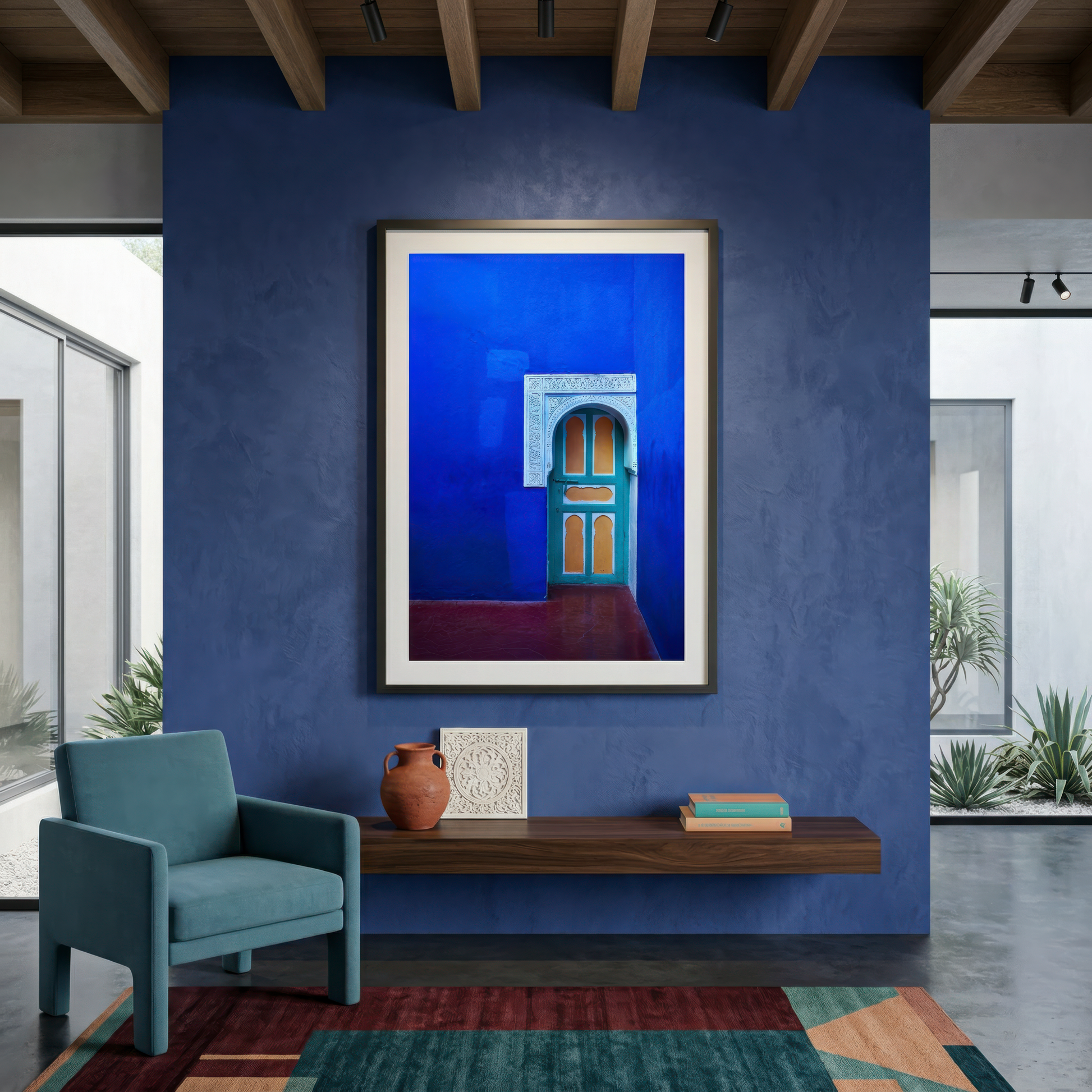 Framed photograph of a doorway in Marrakesh on a blue wall in a modern room with a chair and shelf.
