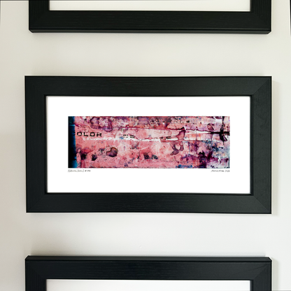 A framed abstract art print with a black frame and white mat, featuring Naturalia II #006 in pink, purple and black tones, mounted on a white wall.

