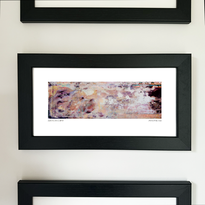 A framed abstract art print with a black frame and white mat, featuring Naturalia II #020 in soft peach and lavender tones, mounted on a white wall.
