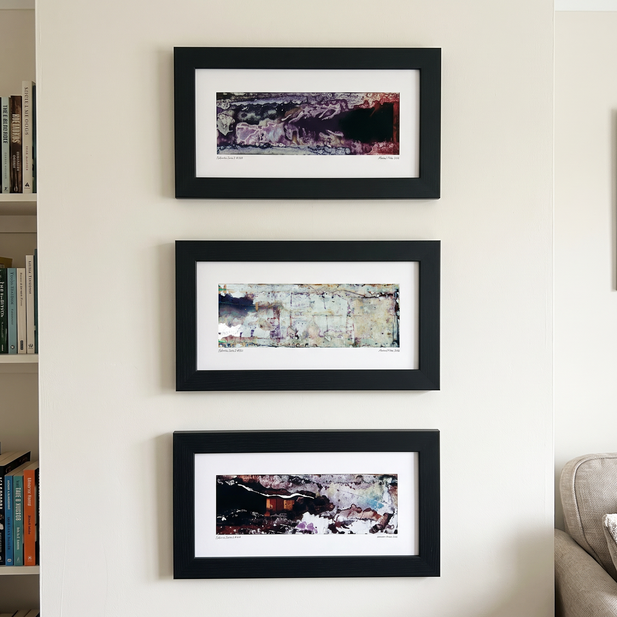 Three framed abstract art prints displayed together on a wall in a modern interior setting.
