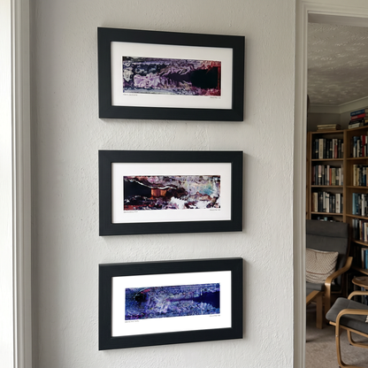 Three framed abstract art prints displayed together on a wall in a modern interior setting.
