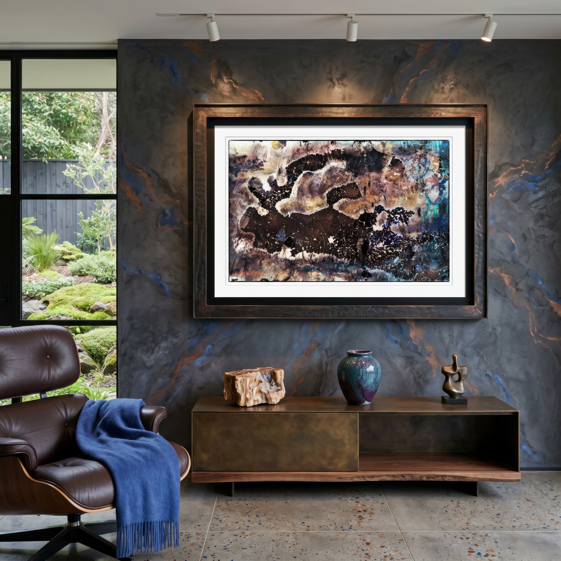 Framed abstract painting on a textured wall with a modern chair and decorative items below.