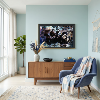 Modern living room with a blue armchair, wooden sideboard, and abstract art on the wall.