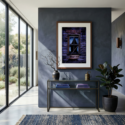 Modern interior with a framed photograph on a dark wall, a glass console table, and decorative items.