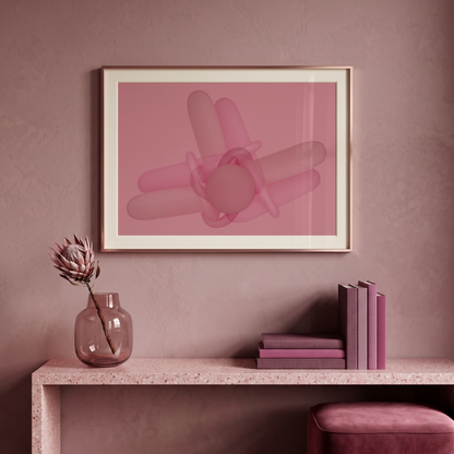 Framed abstract art on a wall with a vase and books on a table below.