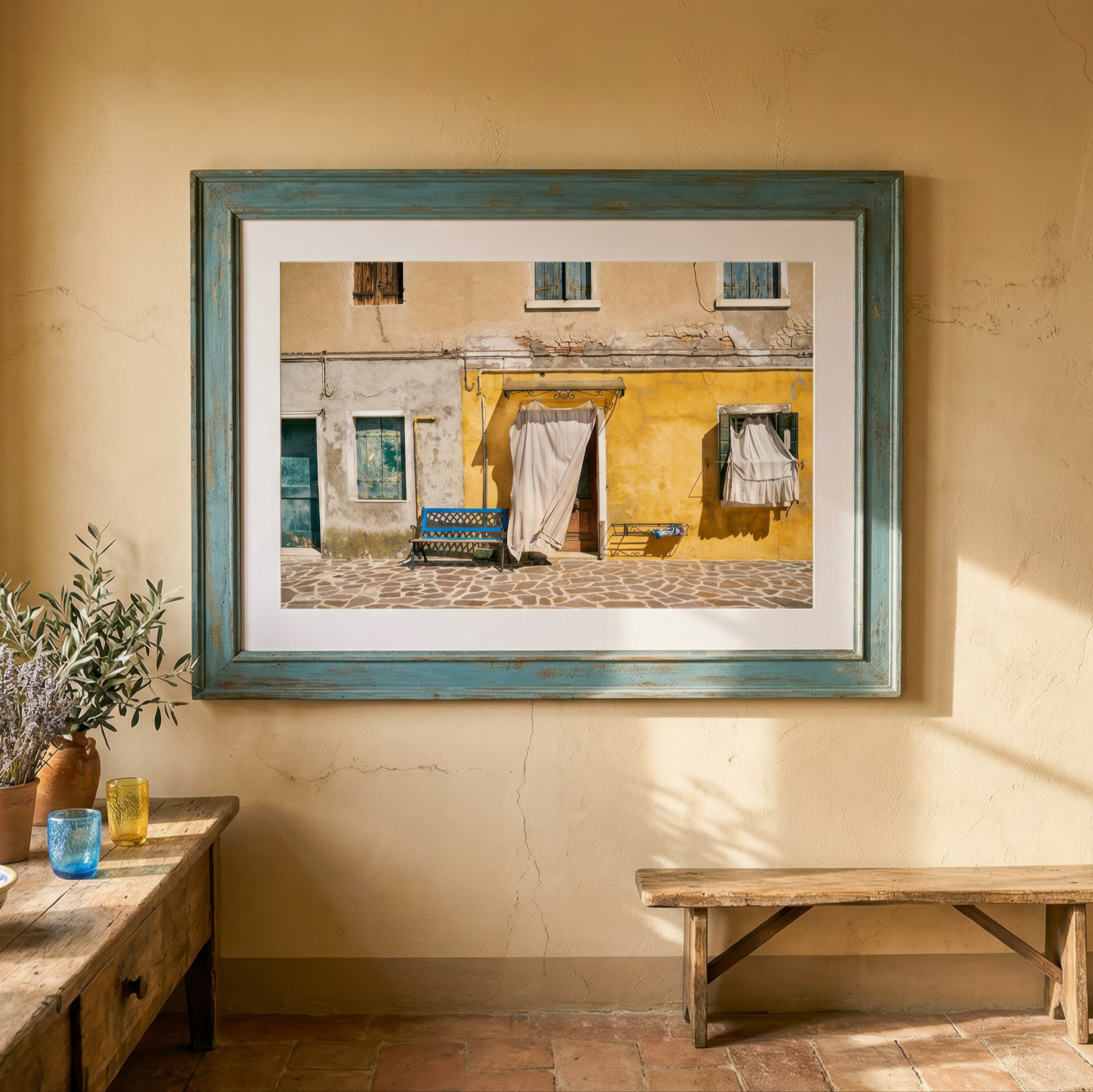 Framed photograph of Venice on a wall in a room with a wooden bench and table.