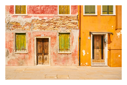 Colorful building facades with wooden doors and windows on a street in Venice Italy