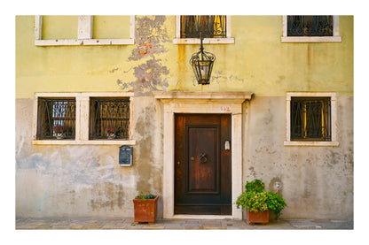 Traditional European building facade with a dark wooden door and decorative elements in Venice Italy