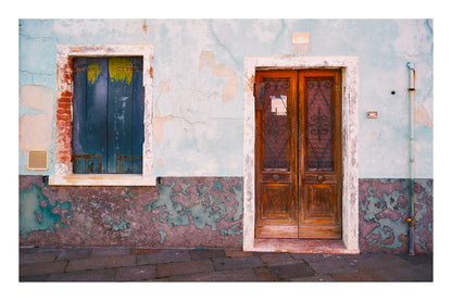 Worn-out building facade with a wooden door and window in an urban setting in Venice Italy