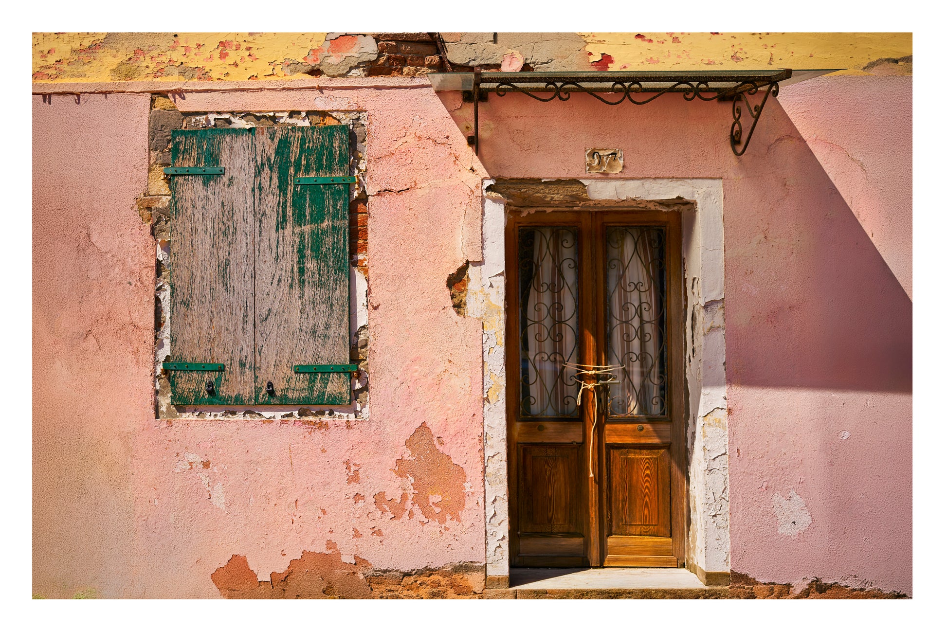Building in Venice with peeling paint and a wooden door.