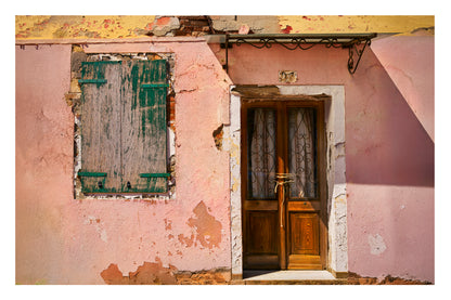Building in Venice with peeling paint and a wooden door.