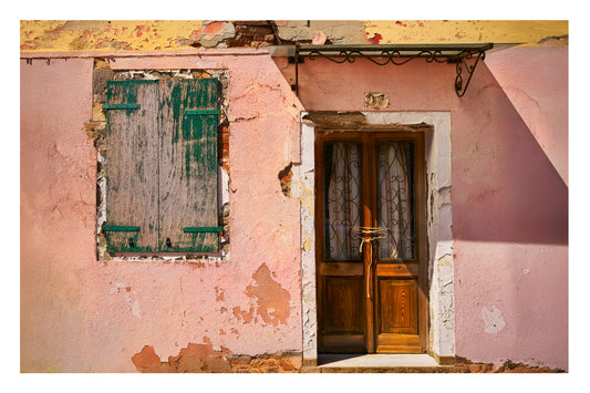 Building in Venice with peeling paint and a wooden door.