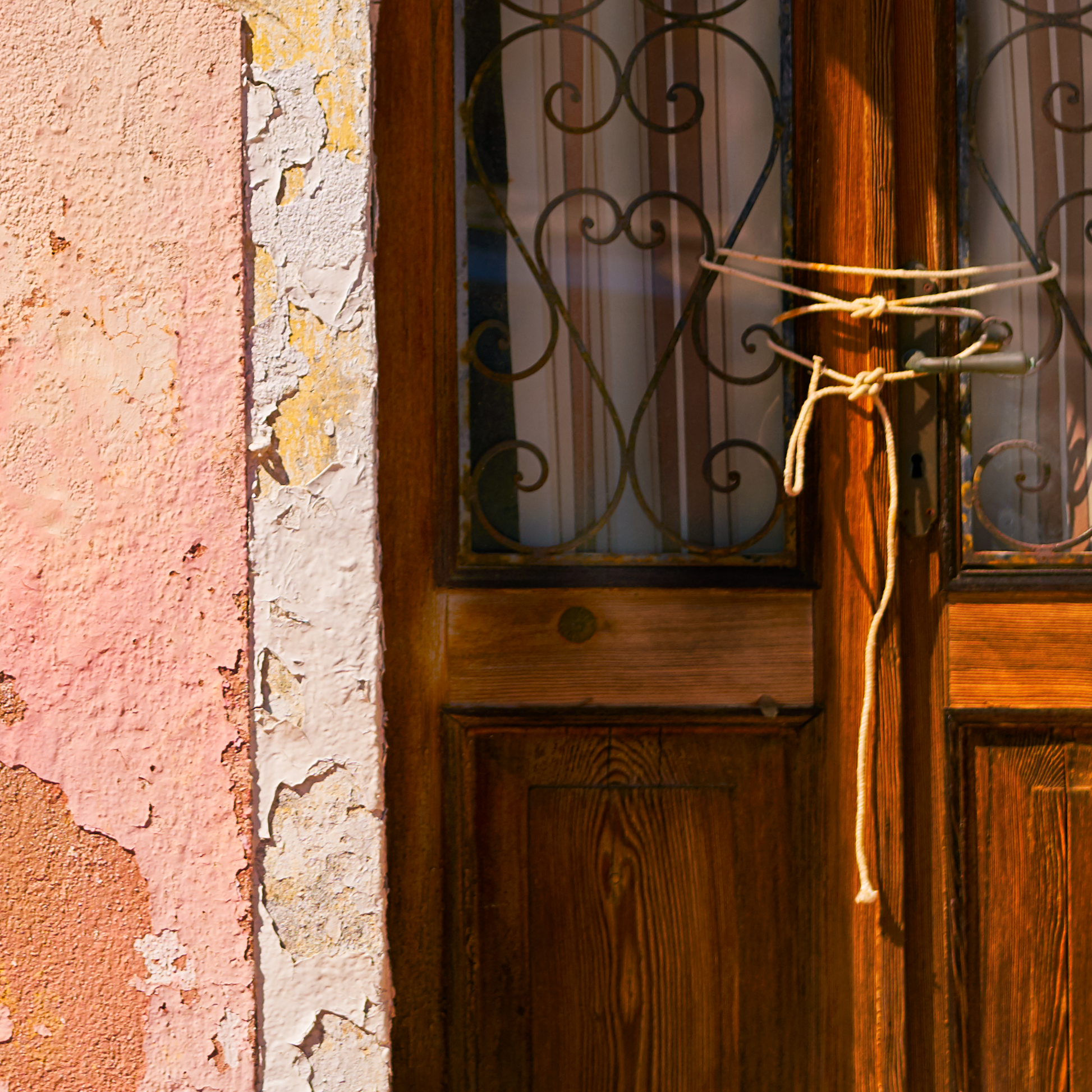 Close up of photograph showing door tied with string and crumbling paintwork