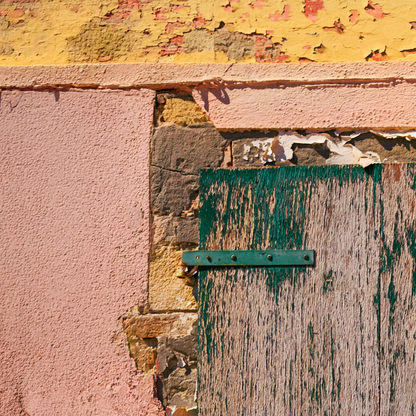 Close-up of a textured wall with peeling paint and a green metal bracket.