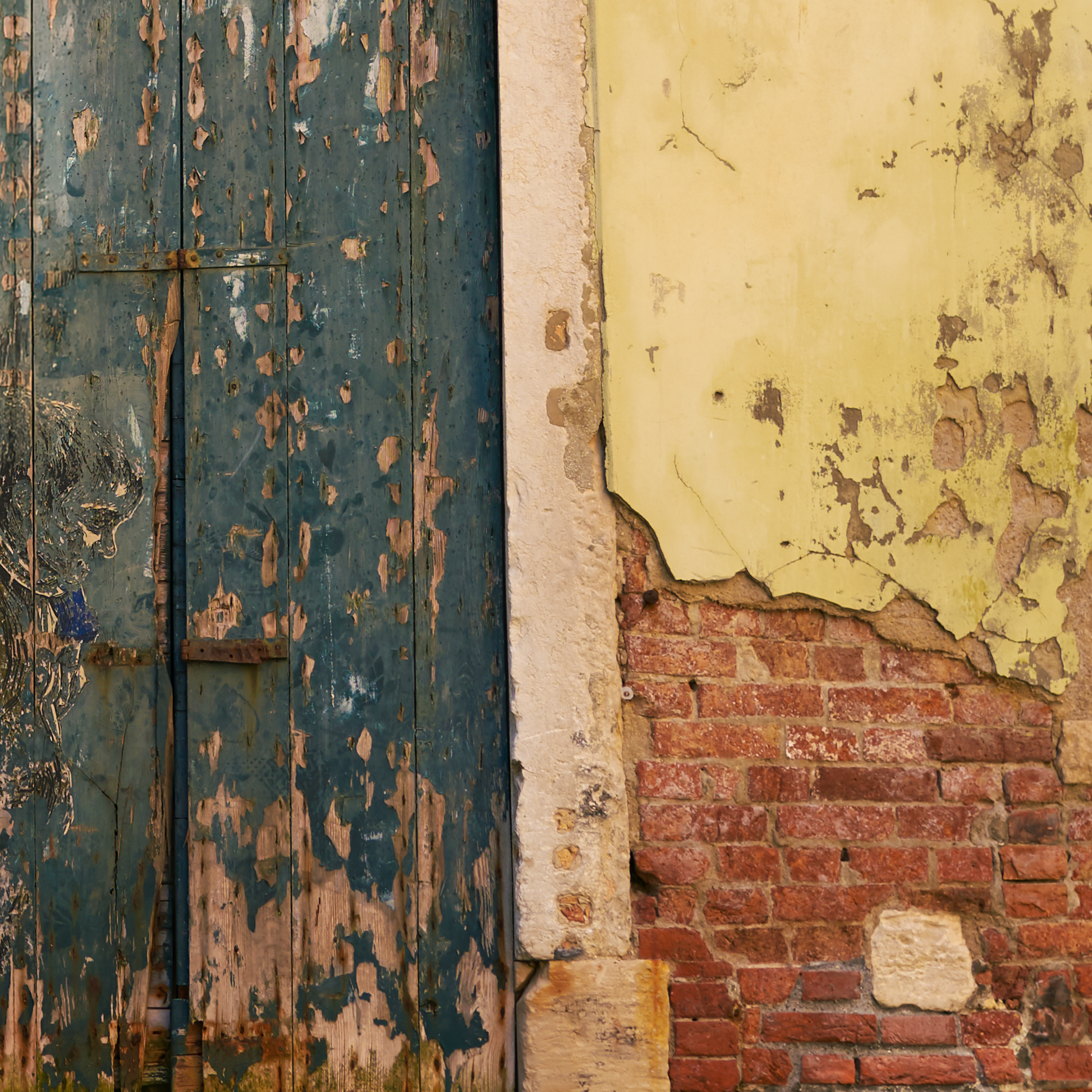 Close-up of a weathered door and wall with peeling paint