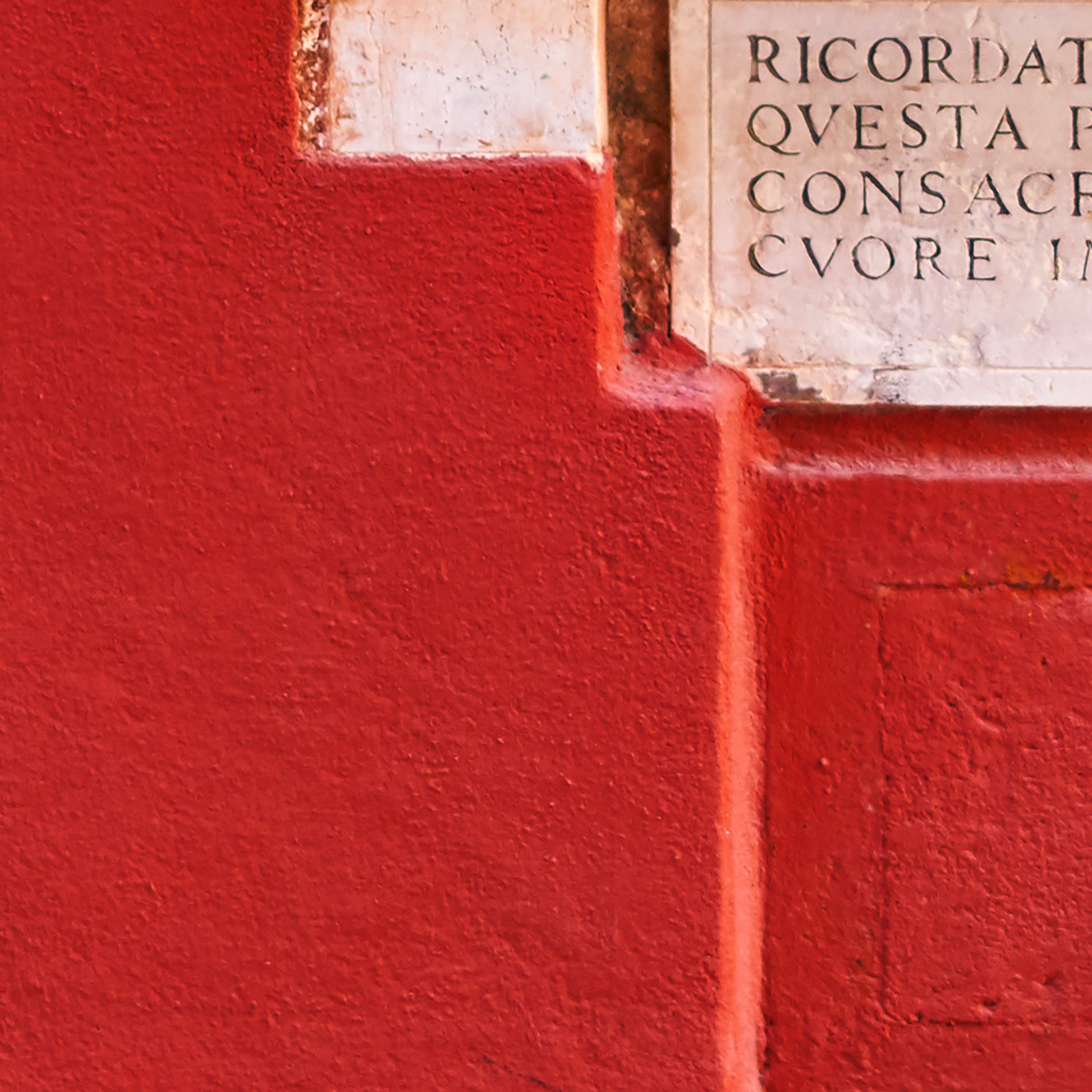 Red wall with a stone inscription