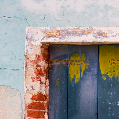 Rustic door with peeling paint on a textured wall