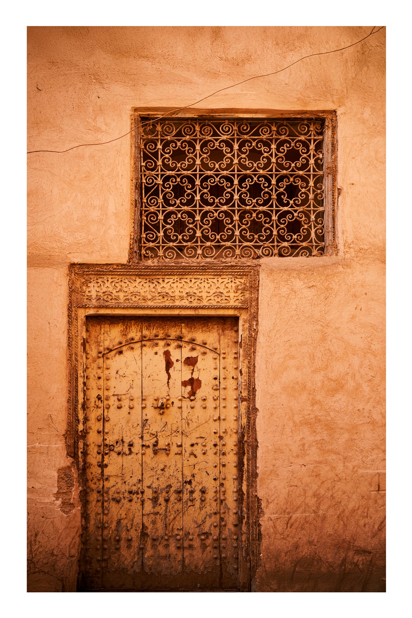 Decorative metal door with intricate patterns on a beige wall in Marrakesh Morocco