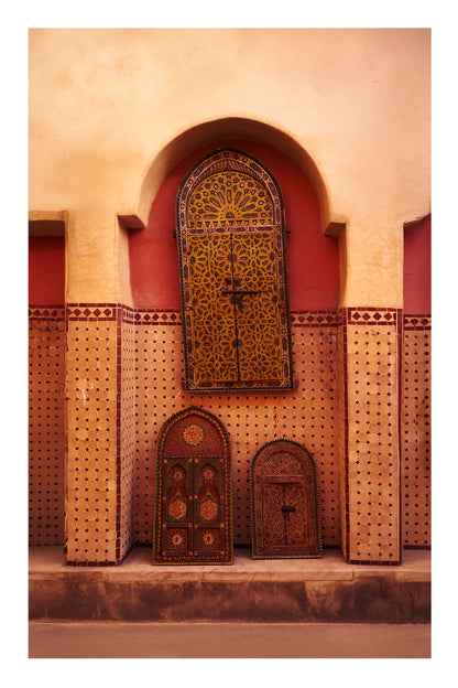 Decorative wooden doors with intricate patterns on a beige wall in Marrakesh Morocco