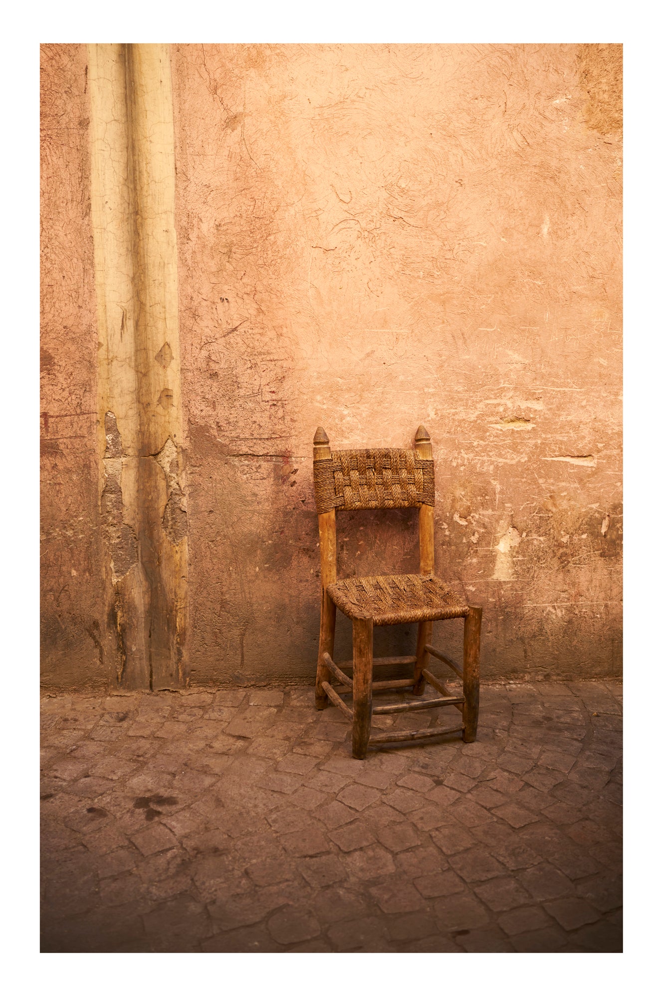 Wooden chair against a textured stone wall in Marrakesh Morocco
