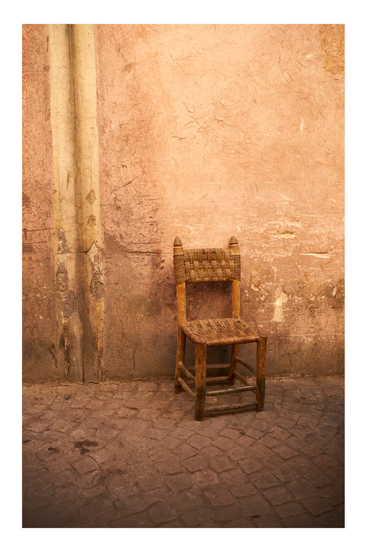 Wooden chair against a textured stone wall in Marrakesh Morocco