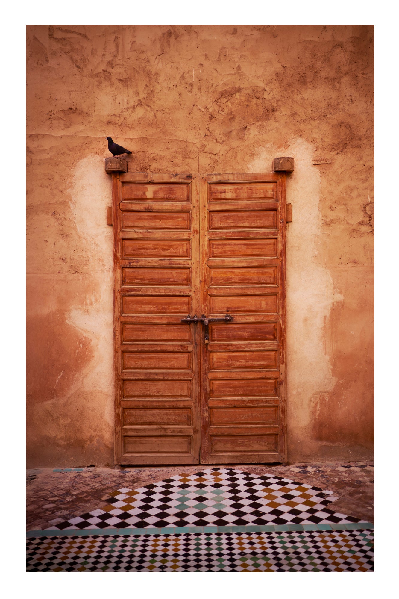 Wooden door on a textured wall with a checkered floor Marrakesh Morocco