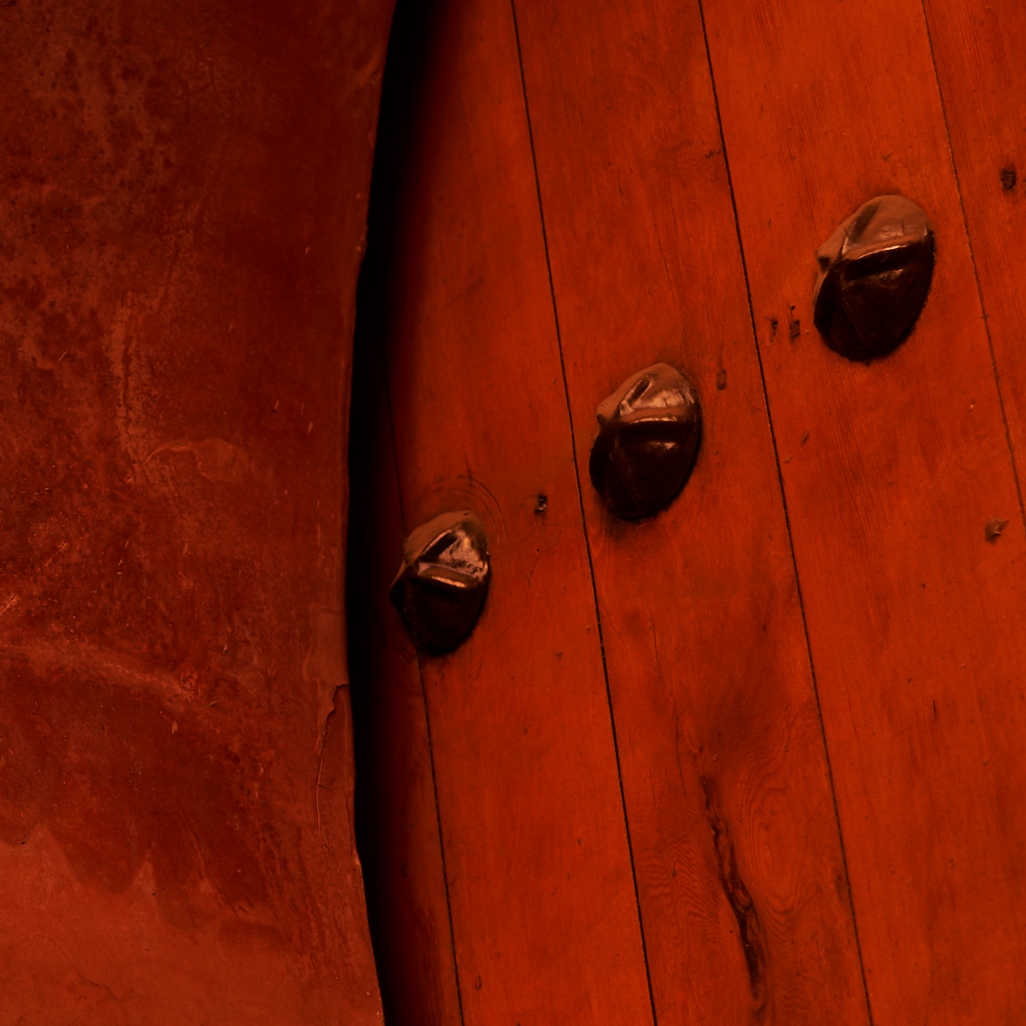Close-up of a wooden door with metal handles.