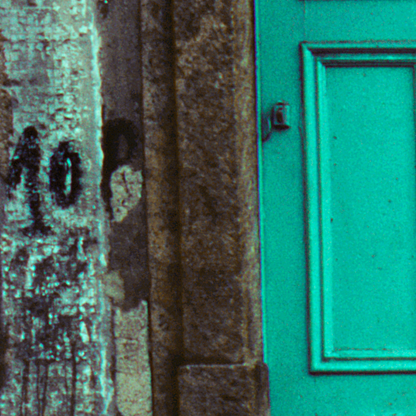 Close-up of a textured wall with a green door