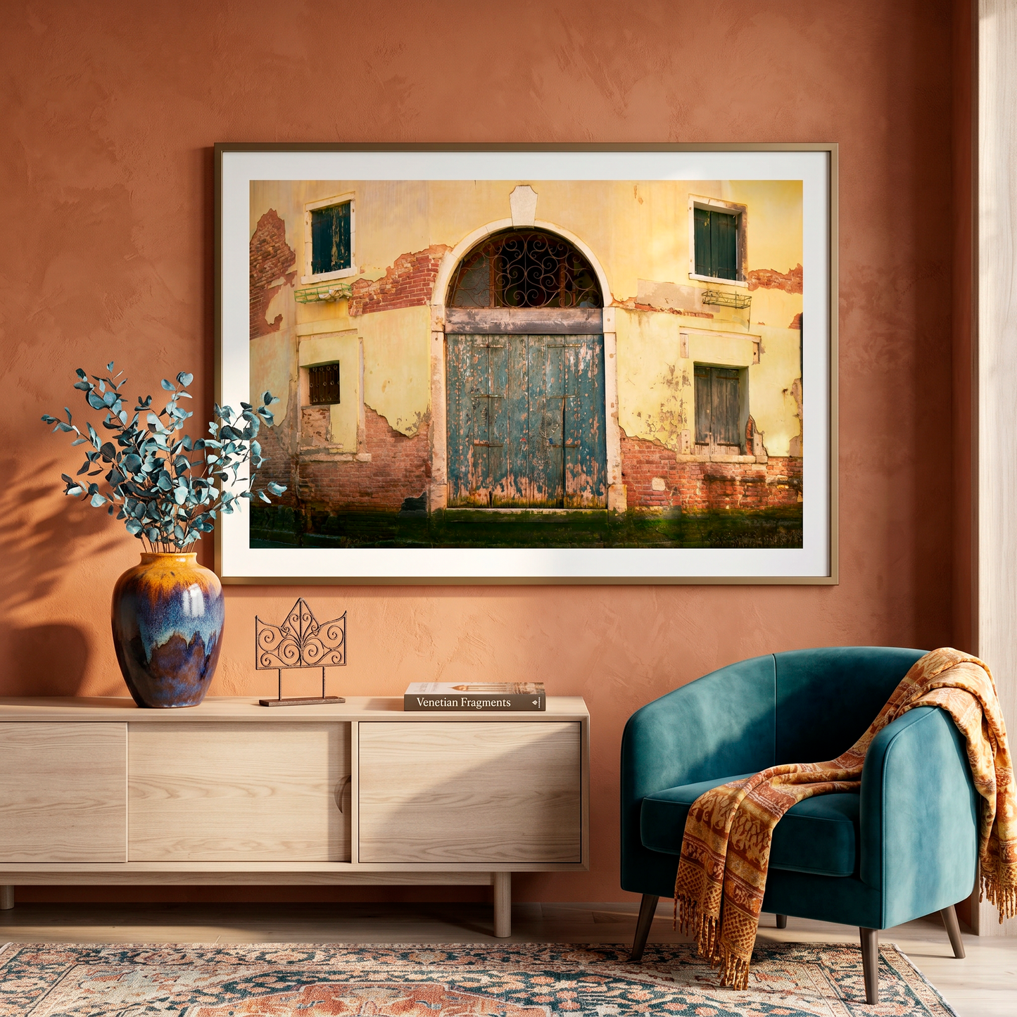 Framed artwork of a building on a wall above a wooden sideboard with decorative items.