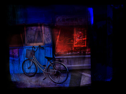 Bicycle in front of a store with neon signs in a dark setting in Taiwan