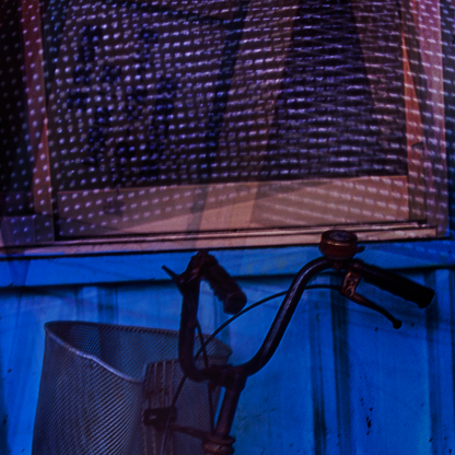 Vintage bicycle with a basket against a textured wall.