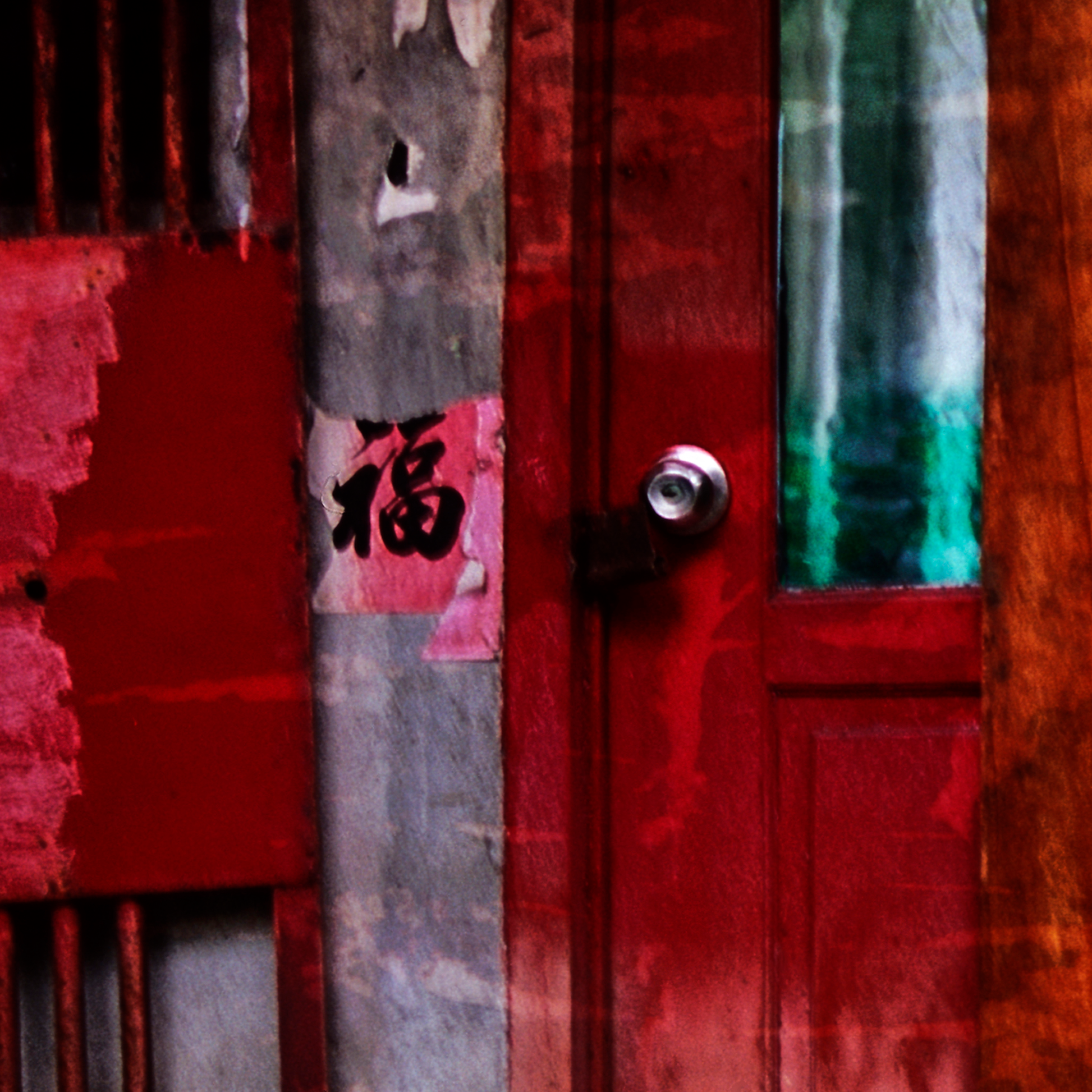 Red door with a metallic handle and Chinese characters, surrounded by colorful graffiti.