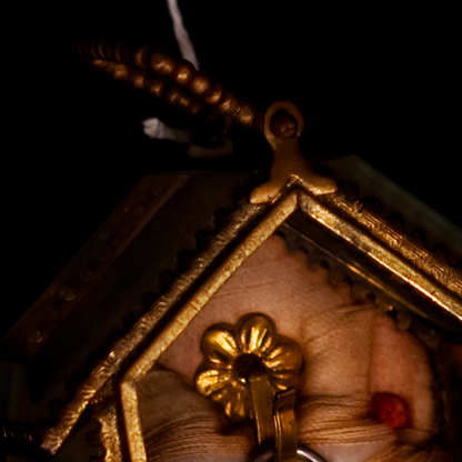 Close-up of a decorative clock with gold detailing and a dark background