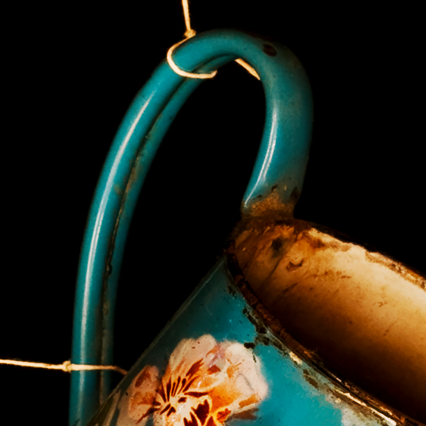 Close-up of a blue ceramic cup with floral design on a black background