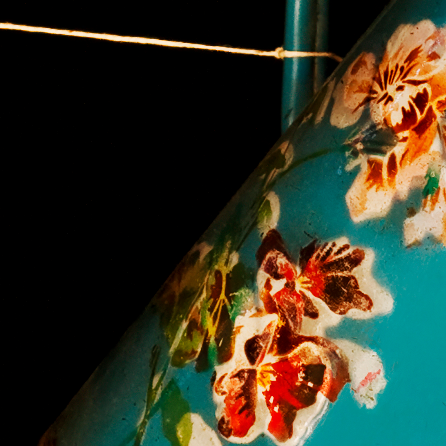 Close-up of a floral design on a blue jug with a dark border.