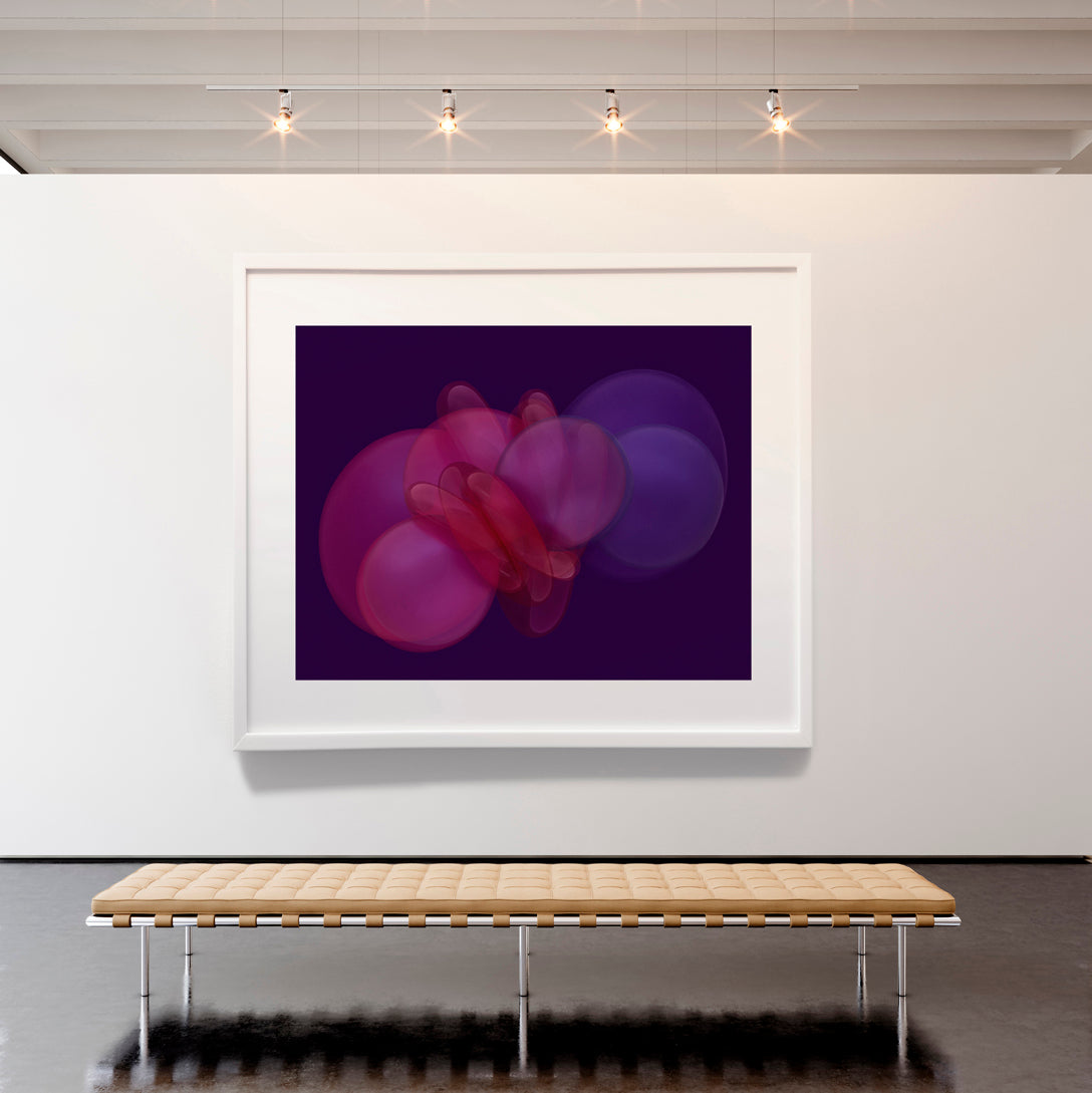 Framed abstract artwork on a white wall with a wooden bench below.