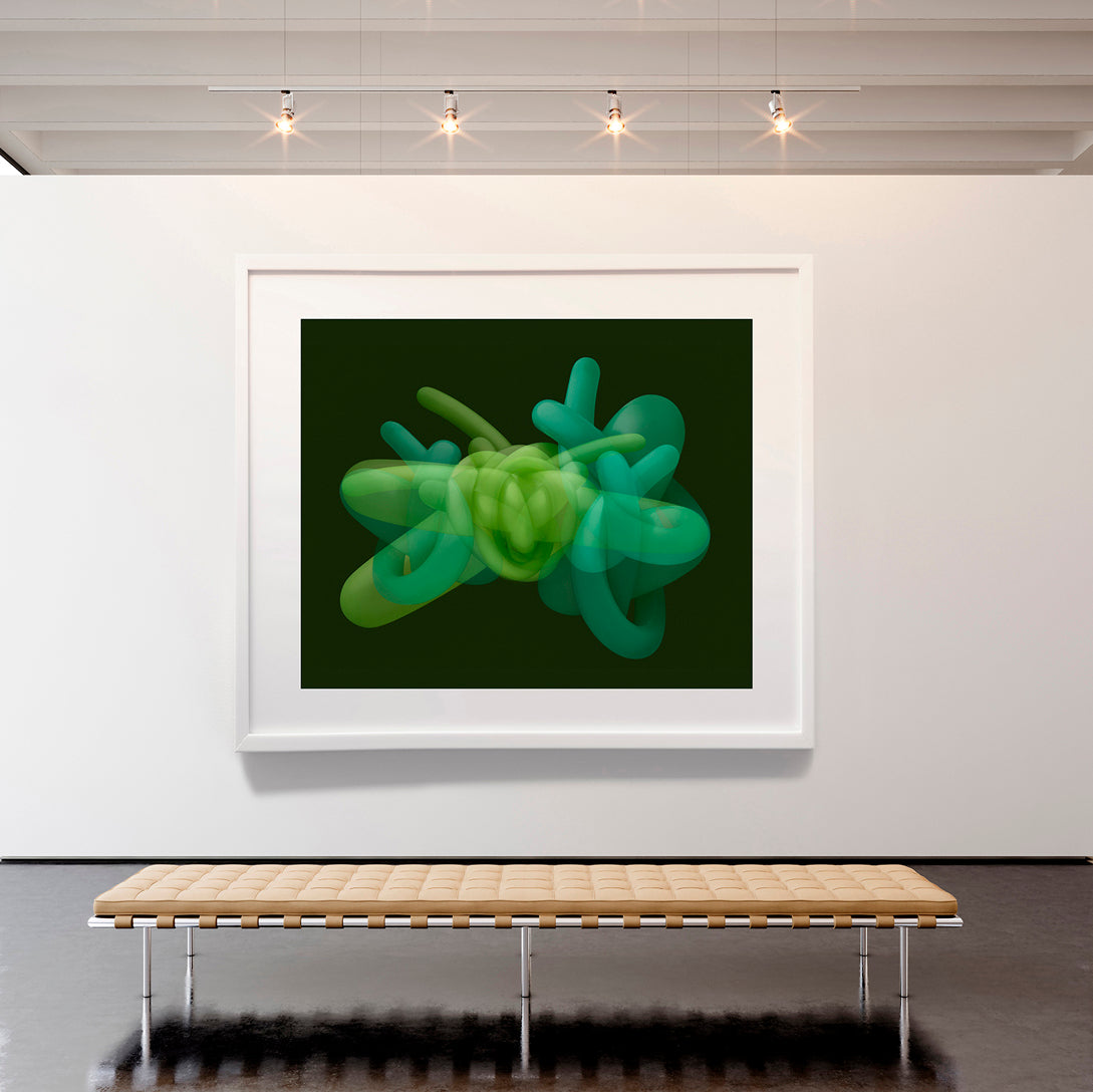 Framed artwork of a green abstract sculpture on a white wall with a bench below.